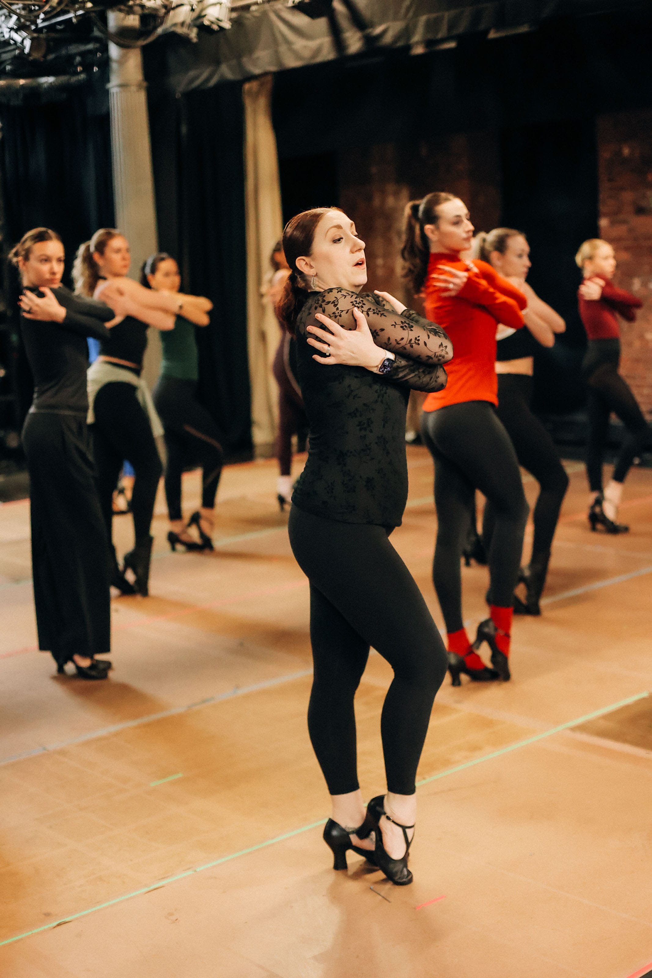 Instructor leading dancers through choreography in rehearsal