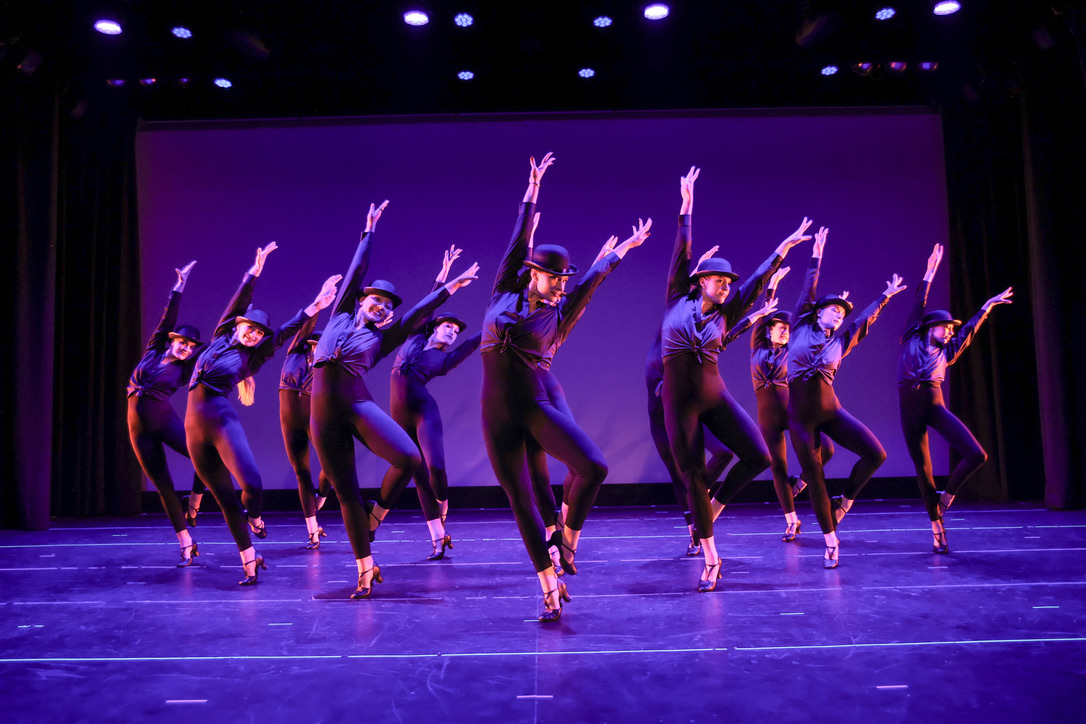 PDC dancers performing precision choreography on stage during the March Intensive live performance